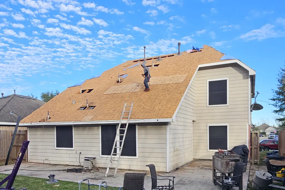 Exposed wood roof sheathing during roofing work.